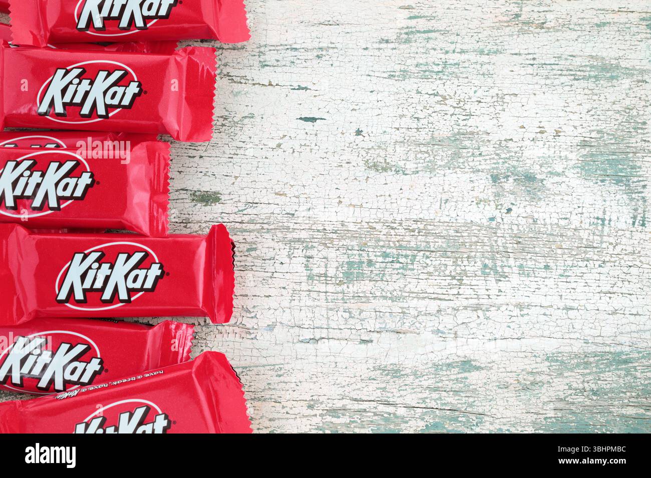 Barrette di cioccolato Kit Kat pacchetti su un vecchio sfondo in legno, cibo e spuntini. Kit Kat è una bacchetta di wafer ricoperta di cioccolato Foto Stock