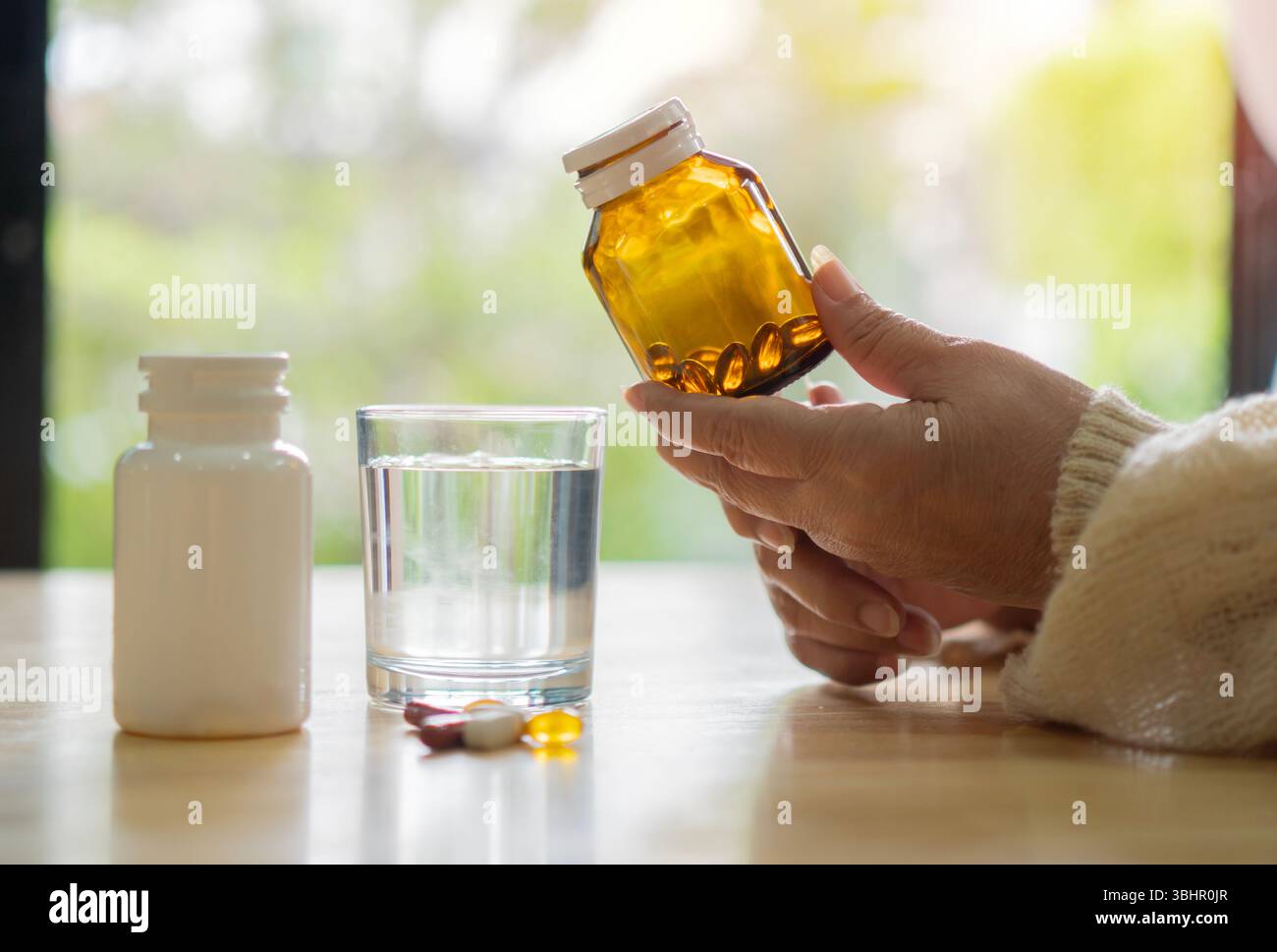 le mani di una donna di 70 anni che tiene le medicine a casa. Concetto di pensionato con farmaci. Primo piano, messa a fuoco selettiva. Foto Stock