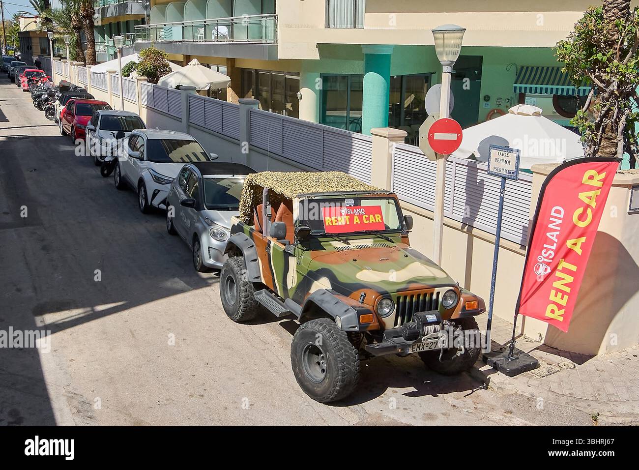 Rodas. Grecia - 11 giugno 2025. Una distintiva jeep mimetica con un cartello "Rent a Car", parcheggiata in una strada di Rodi, che indica le opzioni di noleggio turistico Foto Stock