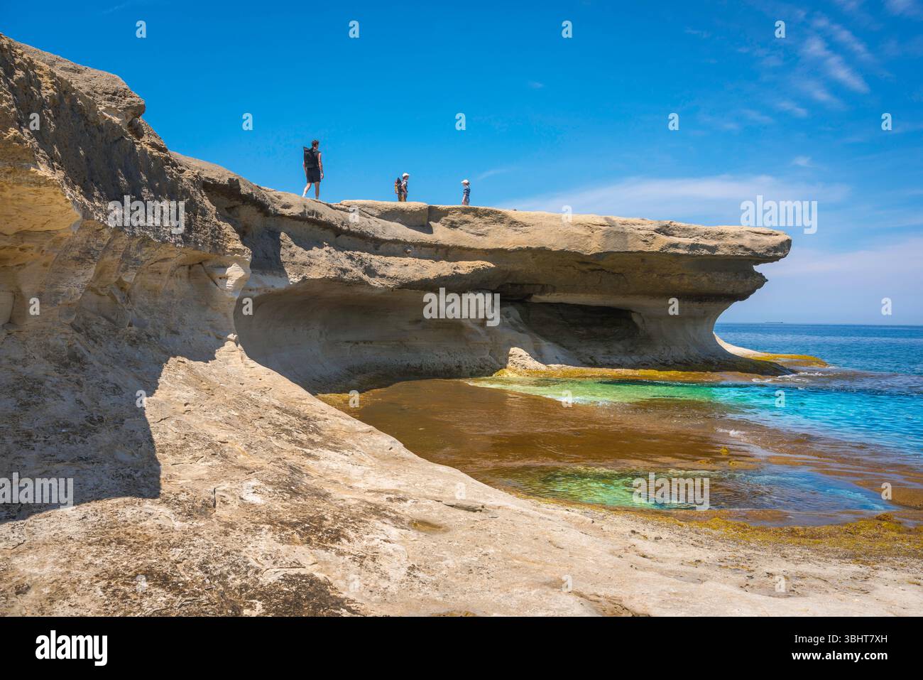 Costa di Malta, ammira in estate la gente che esplora le scogliere calcaree lungo la costa a Xwejni, nella parte settentrionale di Gozo, Malta Foto Stock