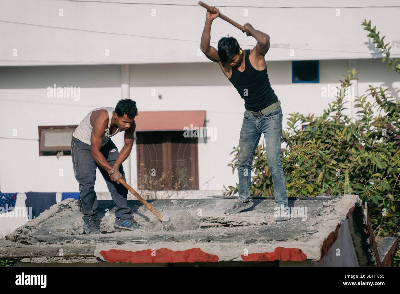 Feb'15th2025 Dehradun Uttarakhand India. Operai edili che utilizzano martello e martelli manuali per smantellare una casa per la nuova costruzione. labo manuale Foto Stock
