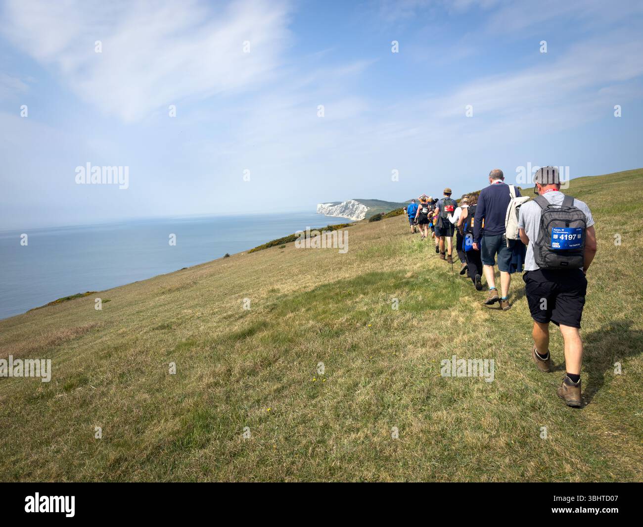 3 MAGGIO 2025 - Isola di Wight, Regno Unito - escursionisti e camminatori che partecipano a un evento di camminata intorno all'Isola di Wight, con vista sul mare fino al Needles An Foto Stock