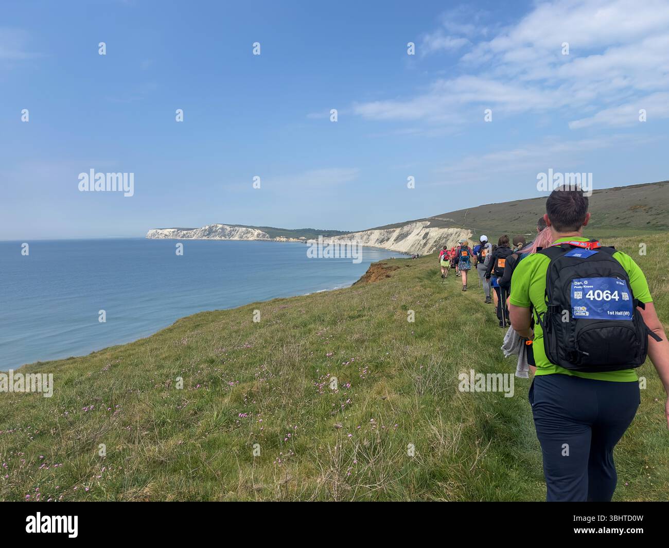 3 MAGGIO 2025 - Isola di Wight, Regno Unito - escursionisti e camminatori che partecipano a un evento di camminata intorno all'Isola di Wight, con vista sul mare fino al Needles An Foto Stock
