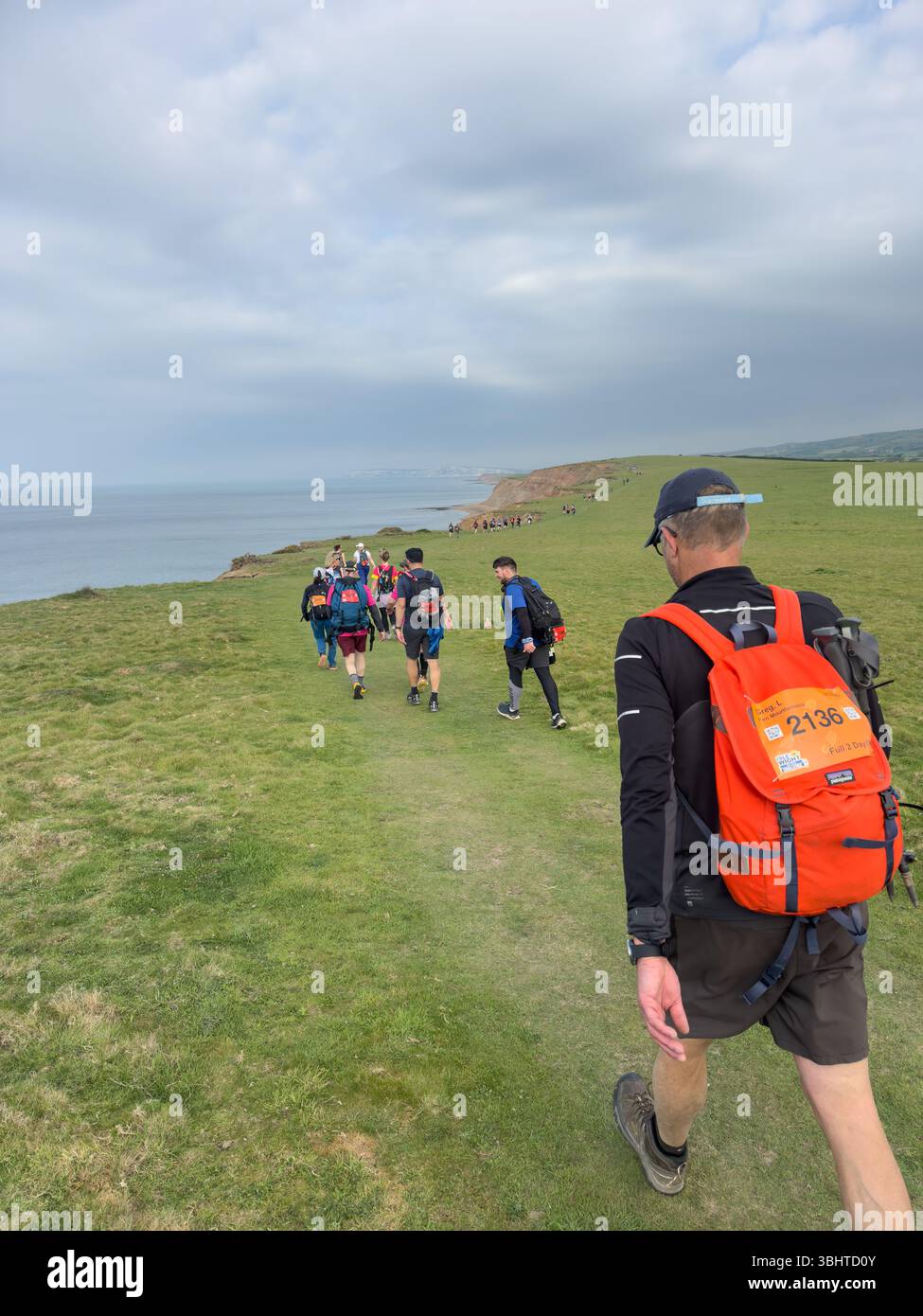 3 MAGGIO 2025 - Isola di Wight, Regno Unito - escursionisti e camminatori che partecipano a un evento di camminata intorno all'Isola di Wight, con vista sul mare fino al Needles An Foto Stock