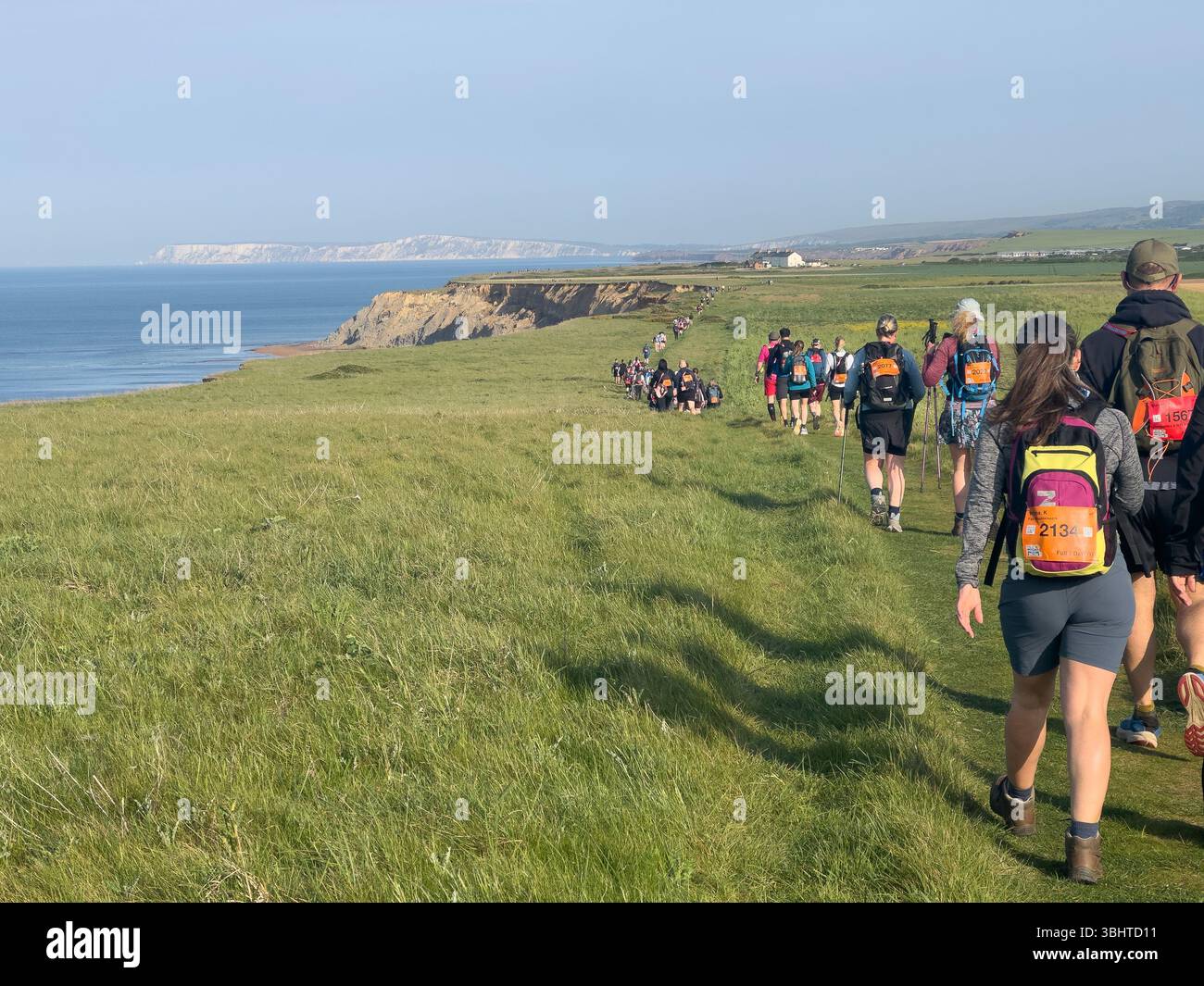 3 MAGGIO 2025 - Isola di Wight, Regno Unito - escursionisti e camminatori che partecipano a un evento di camminata intorno all'Isola di Wight, con vista sul mare fino al Needles An Foto Stock