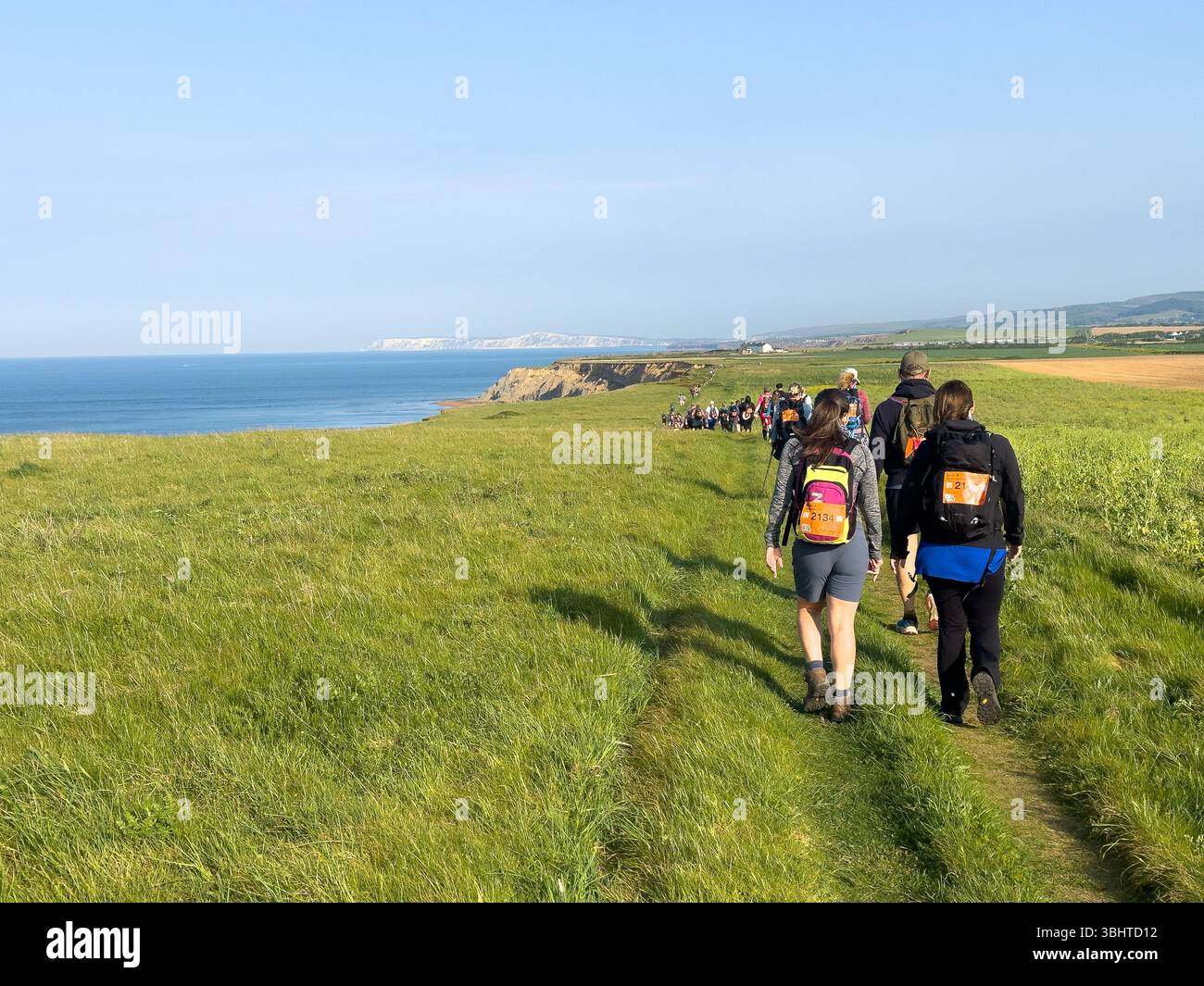 3 MAGGIO 2025 - Isola di Wight, Regno Unito - escursionisti e camminatori che partecipano a un evento di camminata intorno all'Isola di Wight, con vista sul mare fino al Needles An Foto Stock