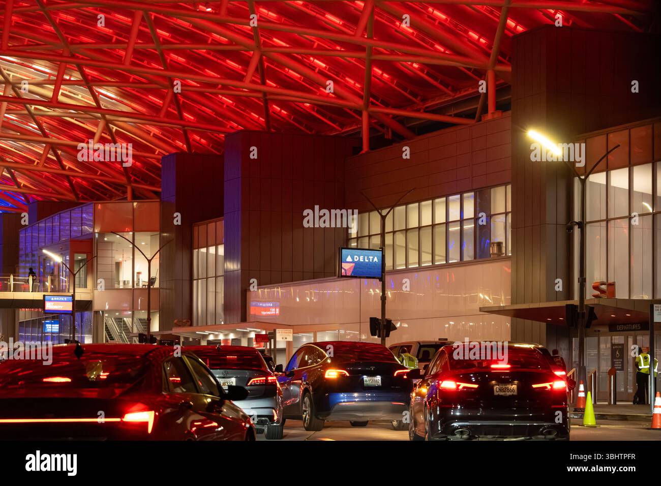 Traffico intenso sotto la colorata tettoia illuminata dell'aeroporto internazionale Hartsfield Jackson di Atlanta, Georgia. (USA) Foto Stock