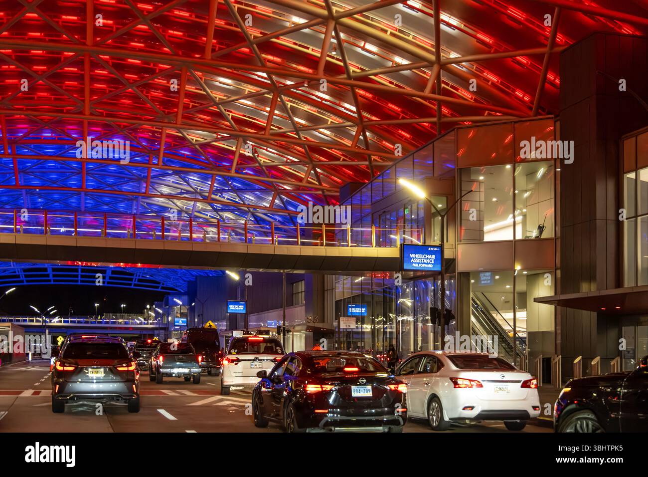 Traffico intenso sotto la colorata tettoia illuminata dell'aeroporto internazionale Hartsfield Jackson di Atlanta, Georgia. (USA) Foto Stock