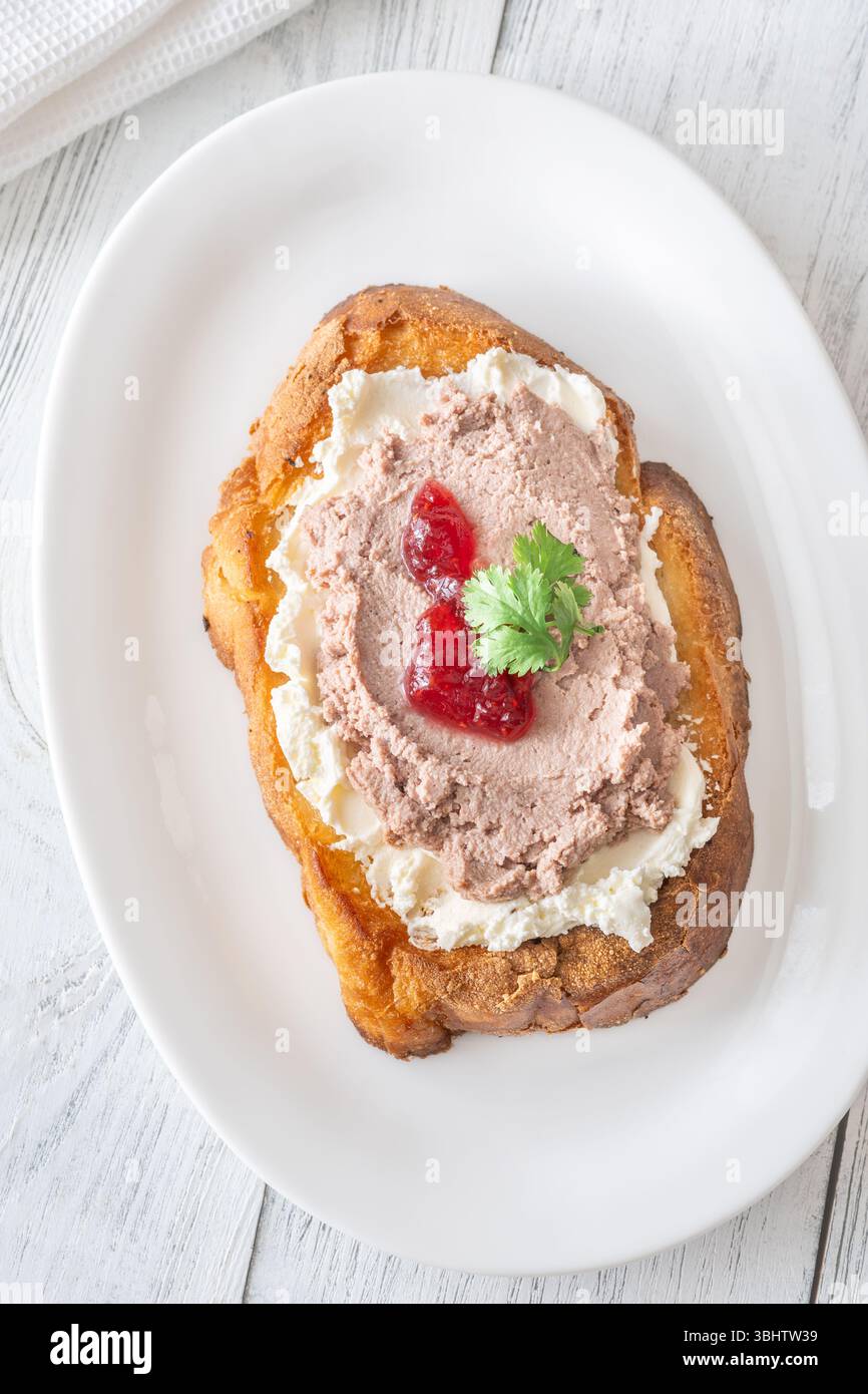 Sandwich di grano tostato con patè, formaggio cremoso e marmellata di mirtilli rossi Foto Stock