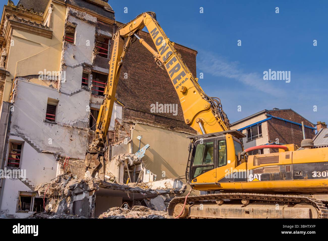 Demolizione di edifici. L'escavatore rompe il vecchio edificio Foto Stock