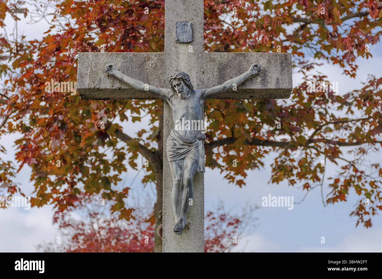 Vecchia statua di Gesù Cristo sulla croce in autunno. Crocifissione, religione e spiritualità, Graz, Austria, Europa Foto Stock