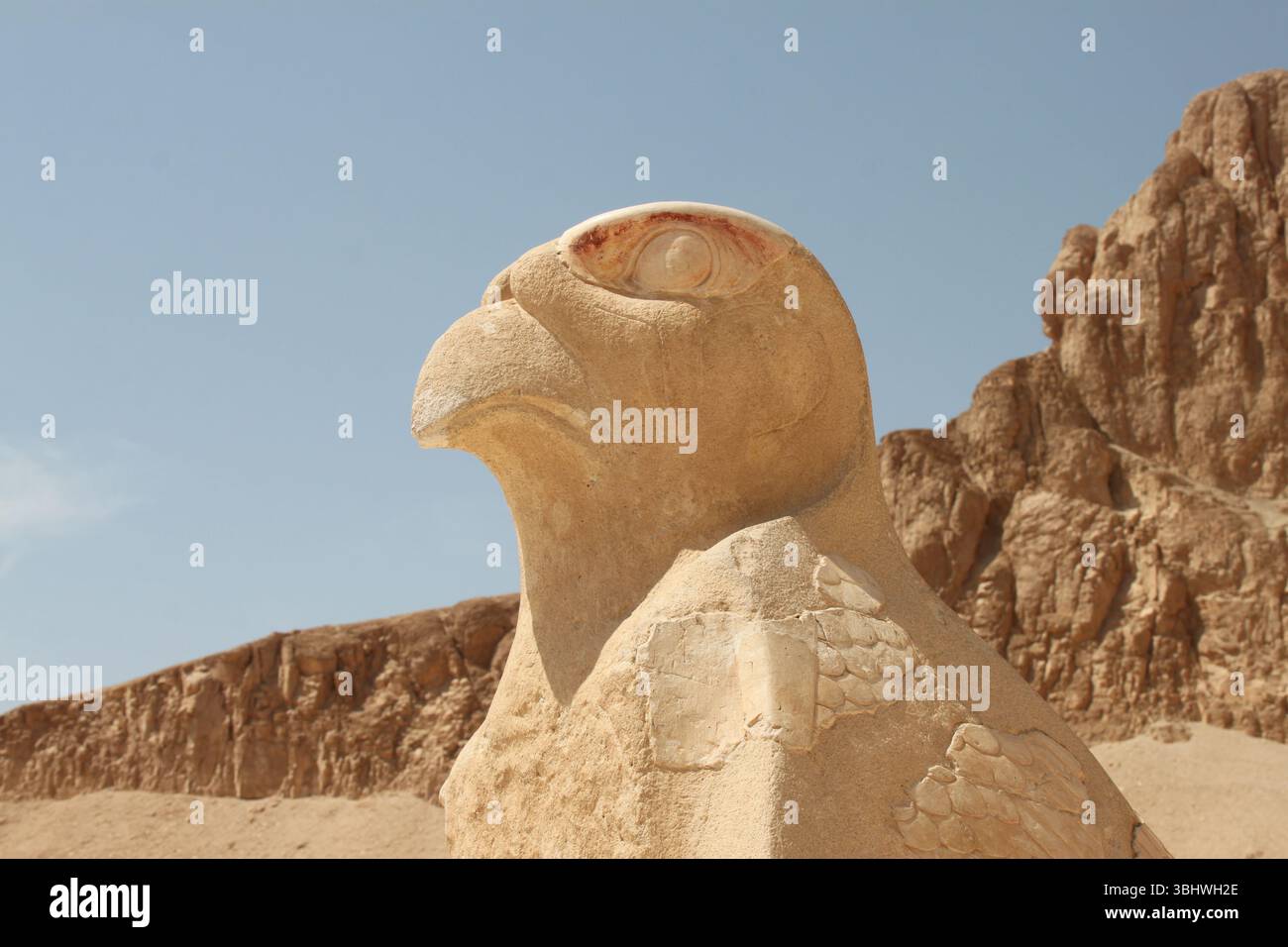 Statua di falco di pietra di Horus contro un'aspra scogliera in Egitto. Foto Stock