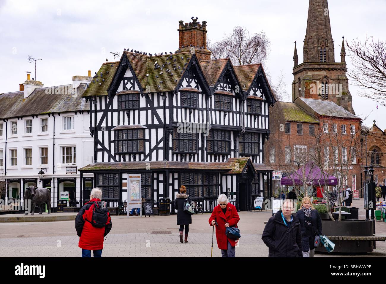 Persone nel centro di Hereford, Hereford Regno Unito; la piazza centrale e il Museo della Casa Bianca e Nera del XVII secolo, un edificio giacobino degli anni '1600 Foto Stock