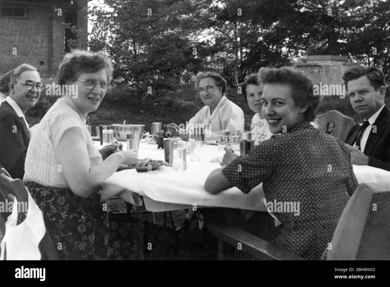 Corrie Ten Boom (centro) e la famiglia si riunirono intorno a un tavolo all'aperto. Foto Stock