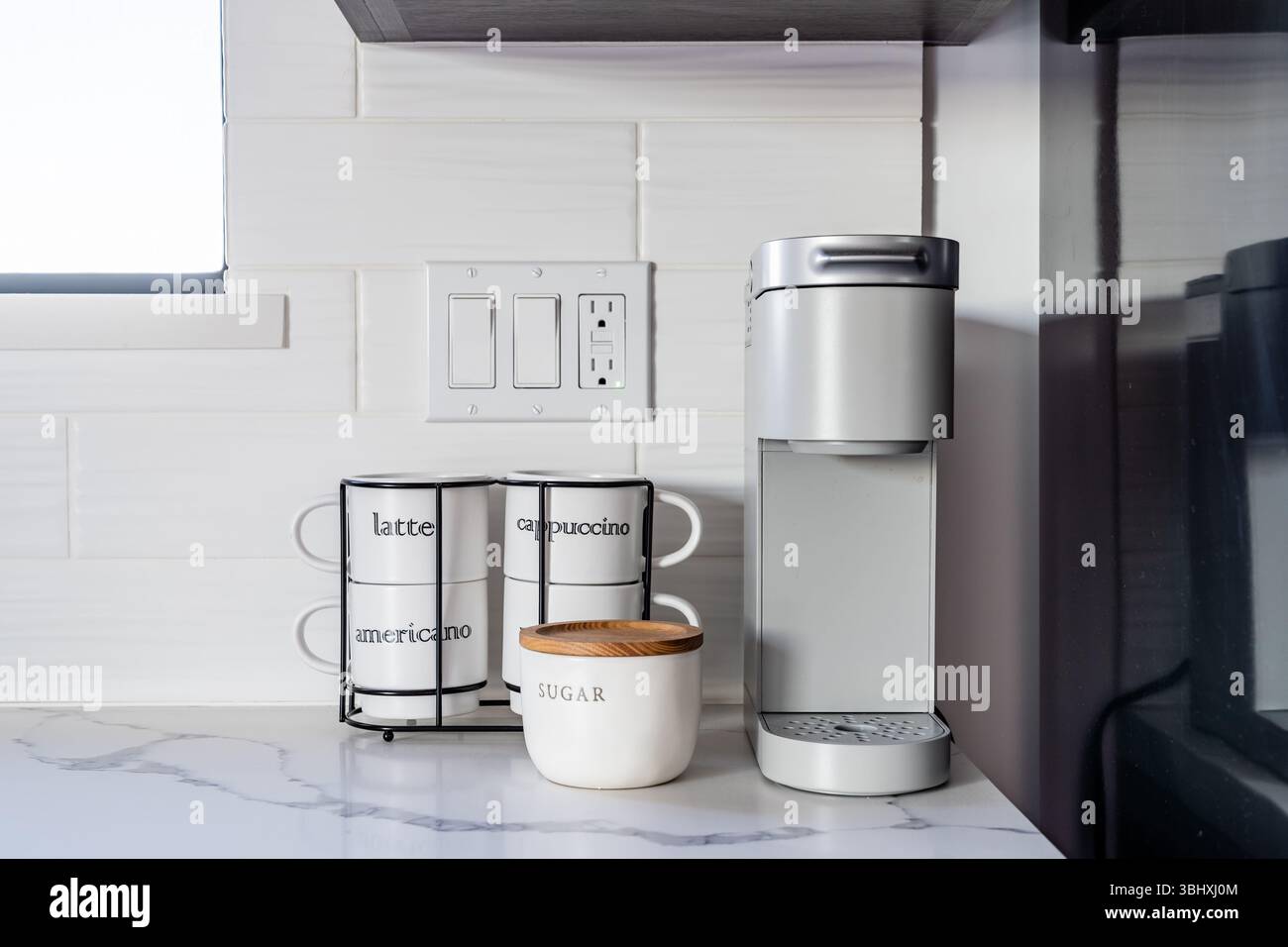 Macchina per il caffè da una tazza con tazze bianche e zucchero in una cucina moderna Foto Stock