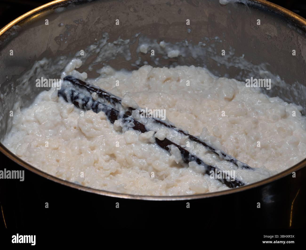 Delizioso budino di riso svedese, risgrynsgröt, con un'importante stecca di cannella, cotto alla perfezione in una pentola. Foto Stock