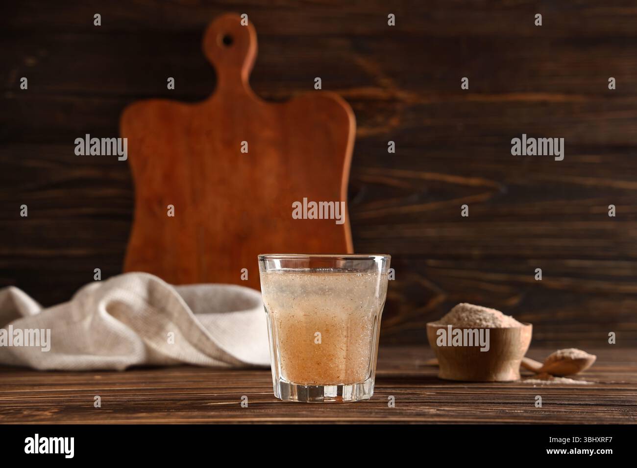 Bicchiere d'acqua con buccia di psico su fondo di legno Foto Stock