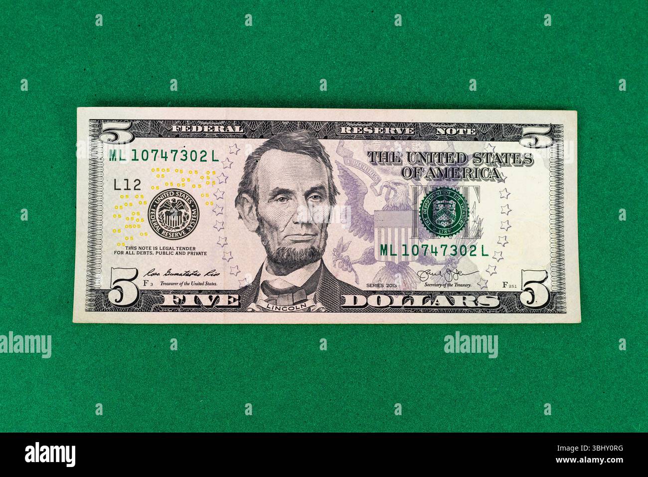 Primo piano della legge da cinque dollari degli Stati Uniti con Abraham Lincoln su sfondo verde Foto Stock