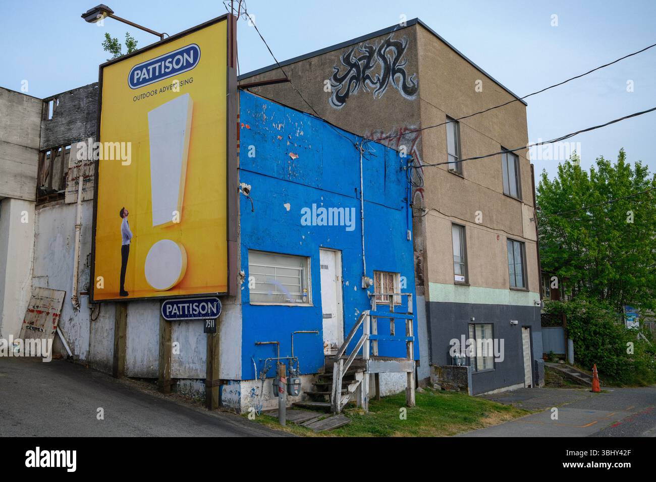 Un vecchio edificio commerciale con un appartamento e un cartellone adiacente a East Vancouver, British Columbia. Foto Stock