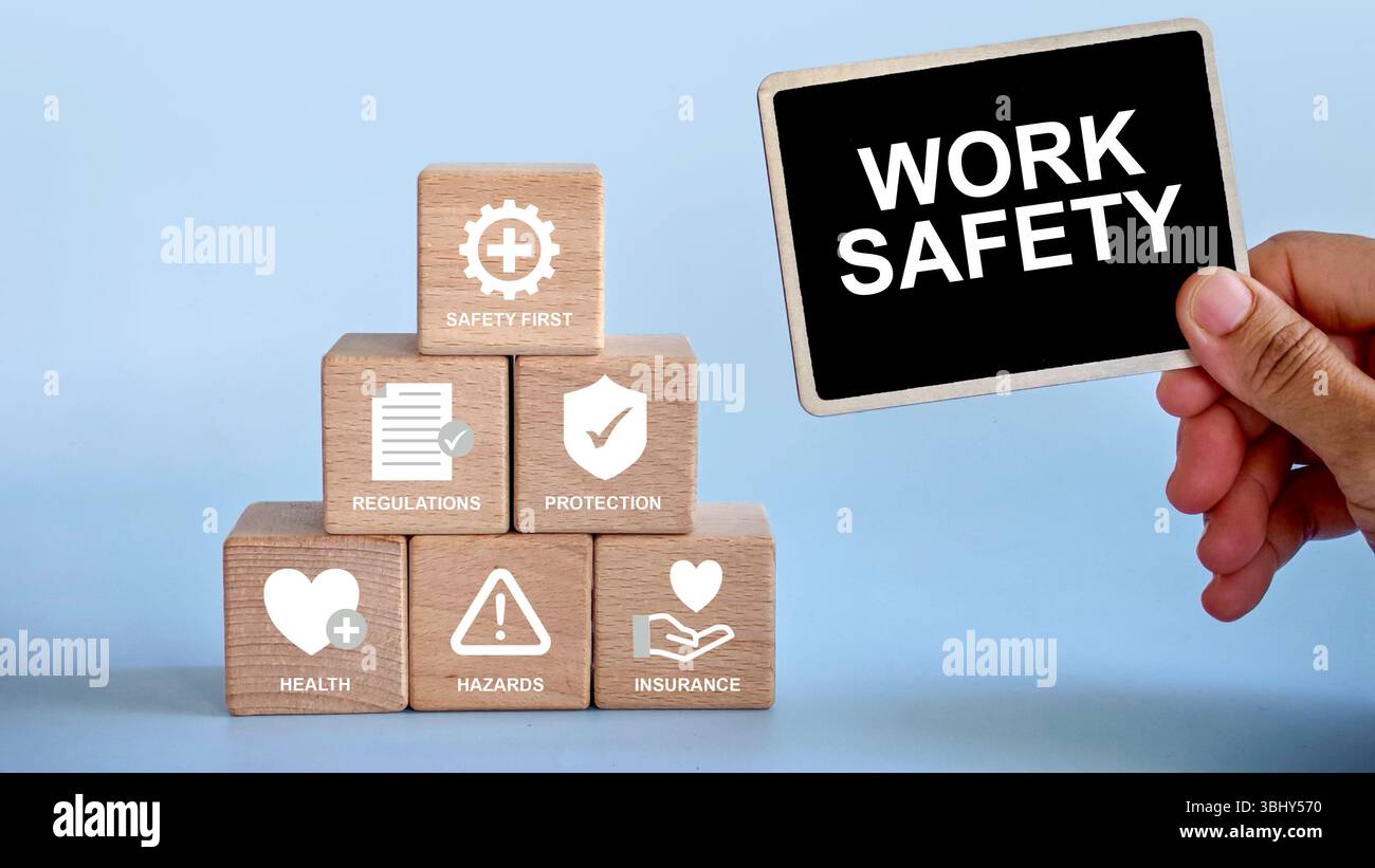 Un cartello di notifica con la scritta "sicurezza sul lavoro" con una pila di cubo di legno con accanto un'icona di sicurezza. Foto Stock