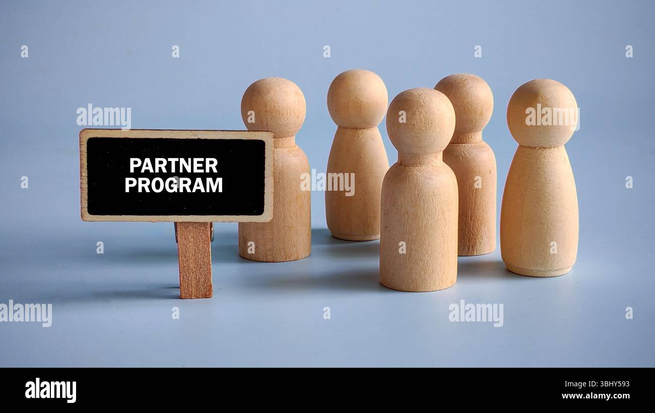 Accanto al cartello scritto con il programma Partner sono presenti persone in legno. Foto Stock