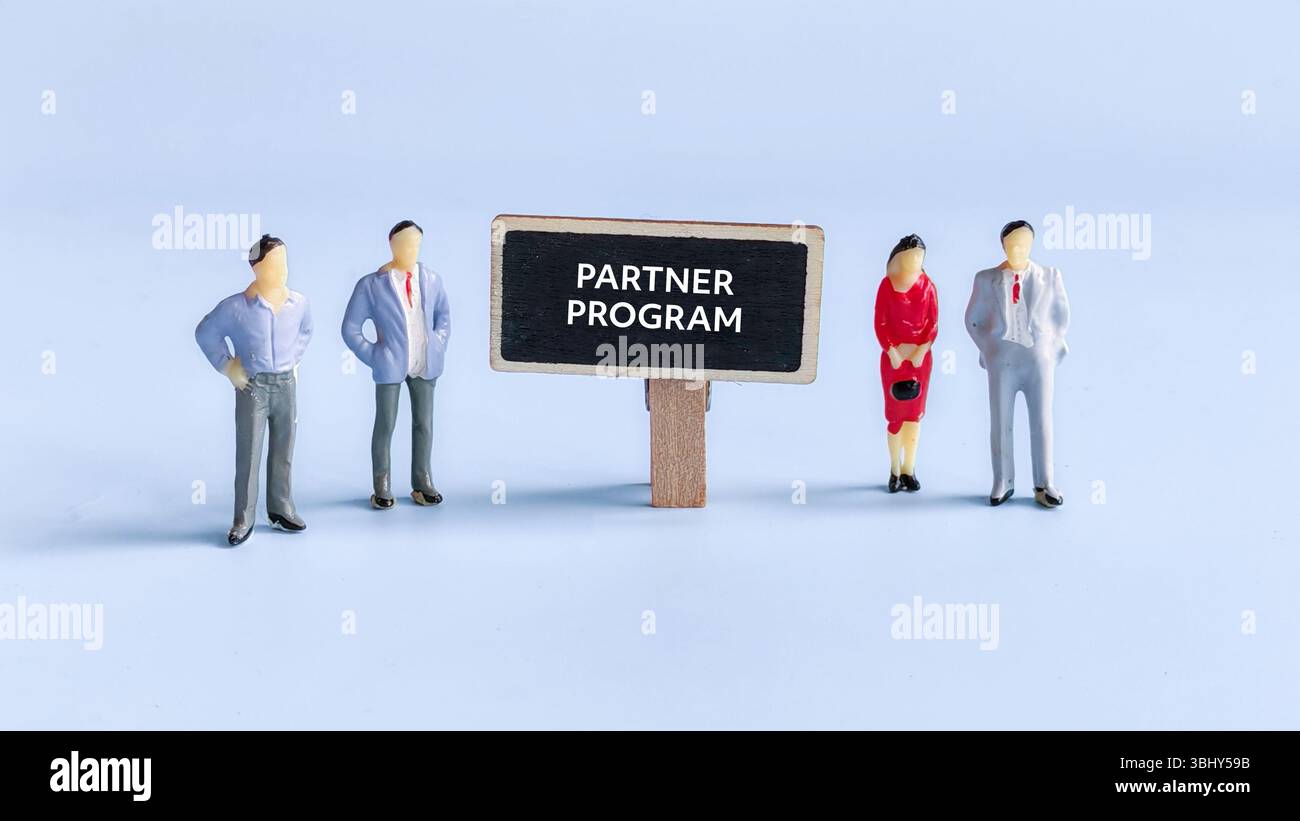 Le persone in miniatura sono accanto al cartello scritto con il programma per i partner. Foto Stock