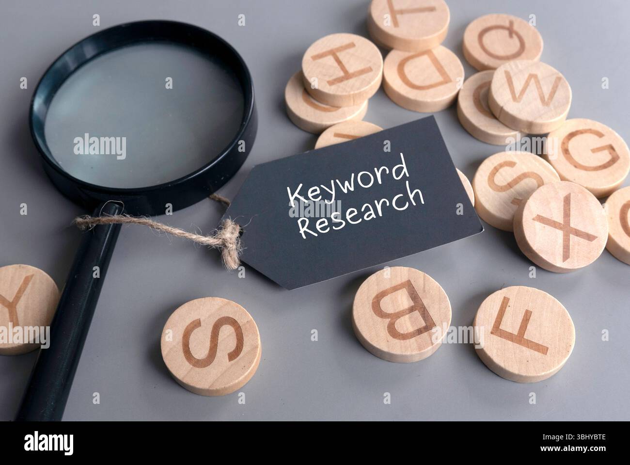 Concetto di ricerca per parole chiave con lente d'ingrandimento e dischi alfabetici in legno Foto Stock