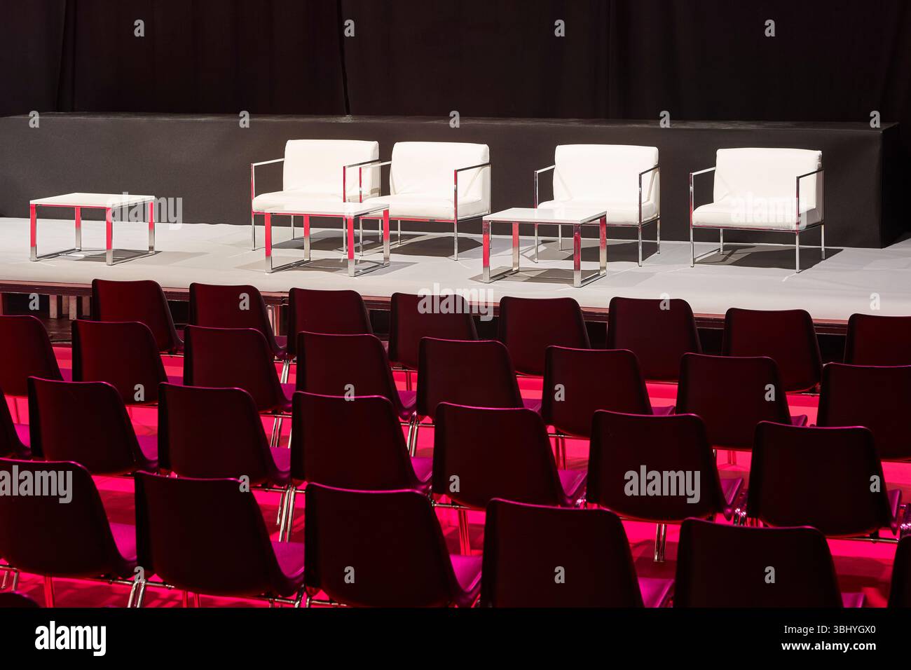 Sala conferenze. Auditorium pieno di sedie illuminato da luce rossa Foto Stock