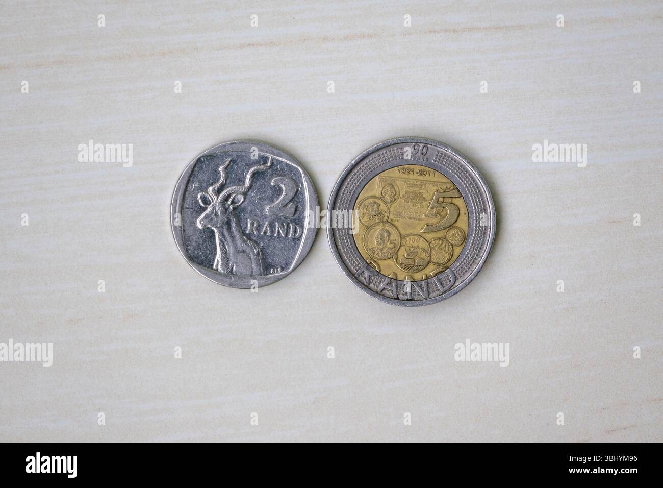 2 Rand e 5 Rand monete sudafricane su una superficie di legno chiaro. valuta del sudafrica due rand e cinque rand. Vista dall'alto Foto Stock
