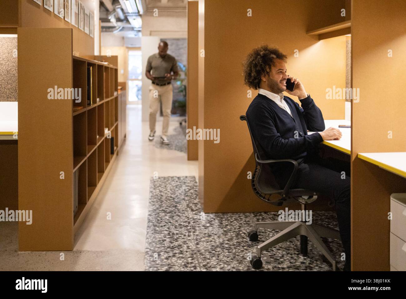 Un moderno spazio di coworking a Barcellona mette in mostra professionisti impegnati in vari compiti. L'ambiente promuove la collaborazione e la produttività in un Foto Stock