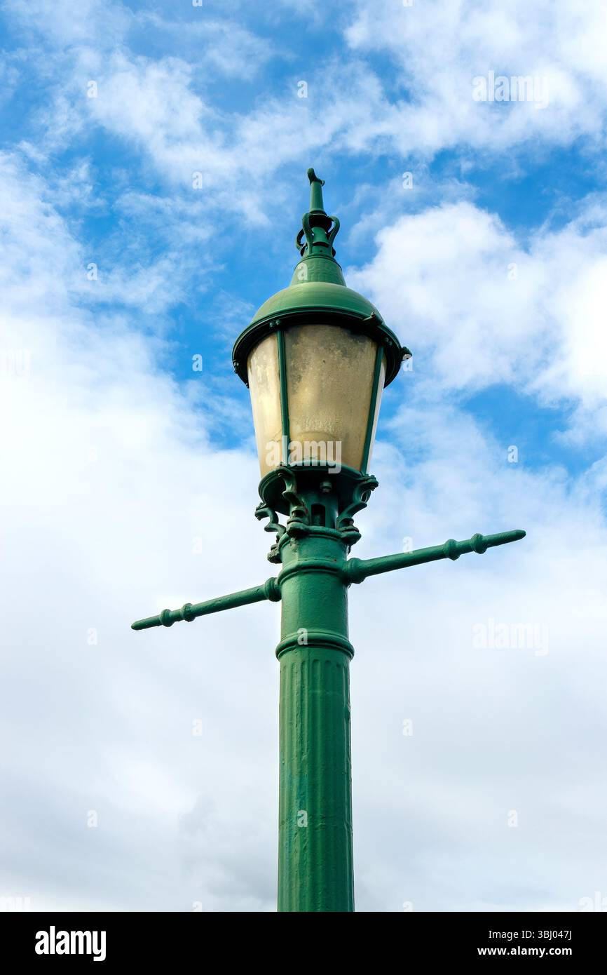 Lampada da strada in ghisa vittoriana d'epoca verde posta sullo sfondo di un cielo nuvoloso vicino al mare a seaton Sluice northumberland in una giornata limpida e luminosa Foto Stock