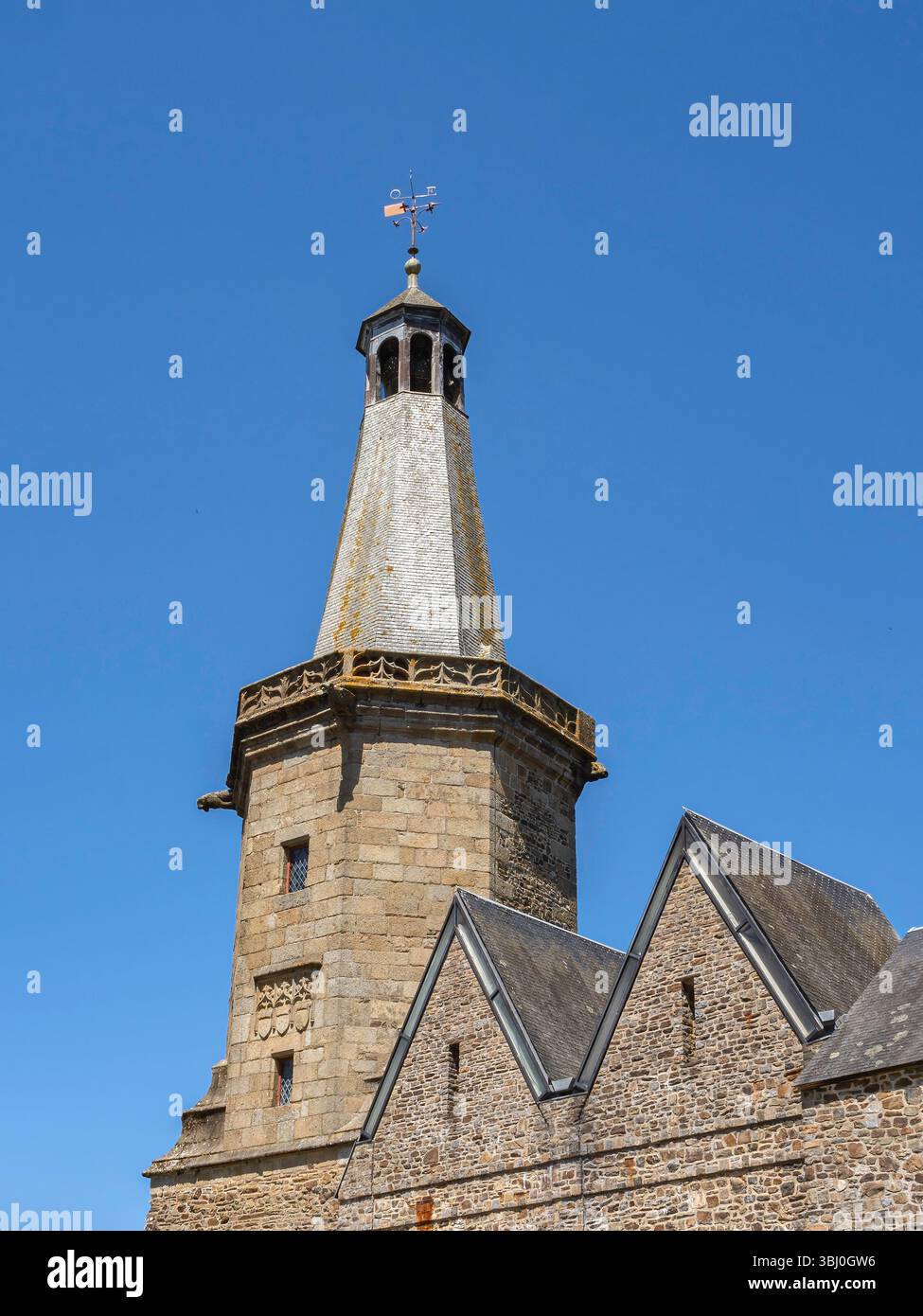 Campanile in pietra di Fougères in Bretagna, costruito nel 1397, visto in una giornata di sole con cielo blu, che si innalza sopra i tetti di ardesia di edifici medievali storici. Foto Stock