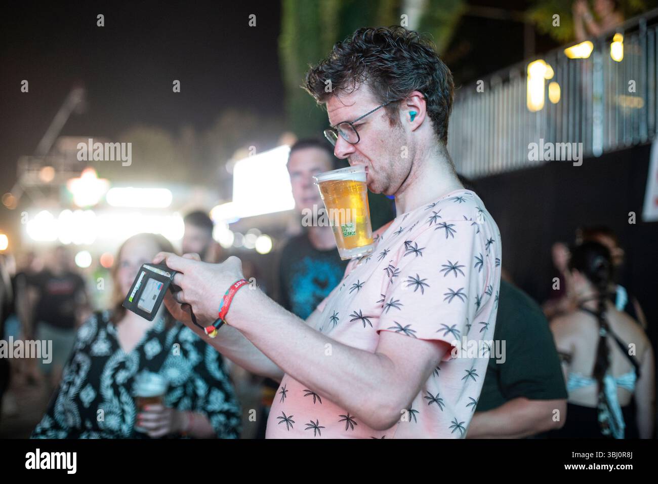 Novi Sad, Serbia. 12 luglio 2024. Uno spettatore del festival tiene un bicchiere di birra all'USCITA DEL festival musicale nella Fortezza di Petrovaradin, Novi Sad, Serbia, il 12 luglio 2024. (Foto di Maxim Konankov/NurPhoto)0 credito: NurPhoto SRL/Alamy Live News Foto Stock