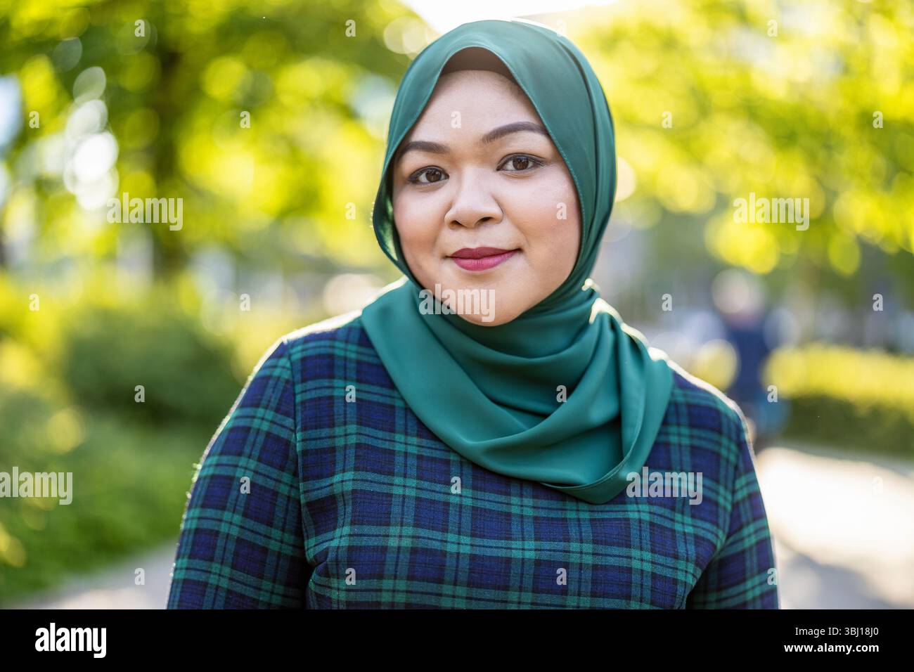 Ritratto di donna musulmana asiatica che indossa hijab sorridente alla macchina fotografica Foto Stock
