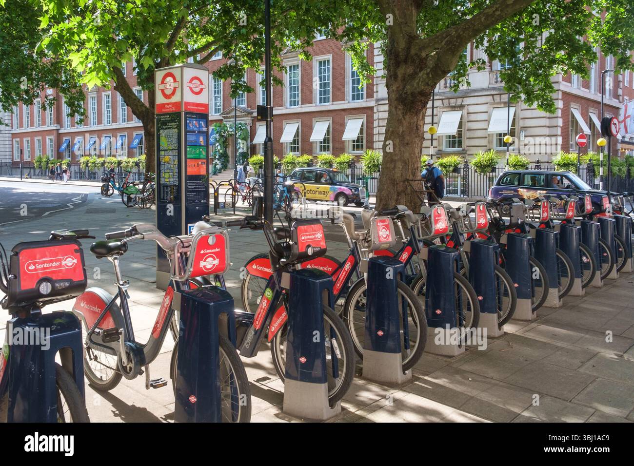 Una fila di Santander noleggia biciclette a Grosvenor Square, Mayfair, Londra Foto Stock