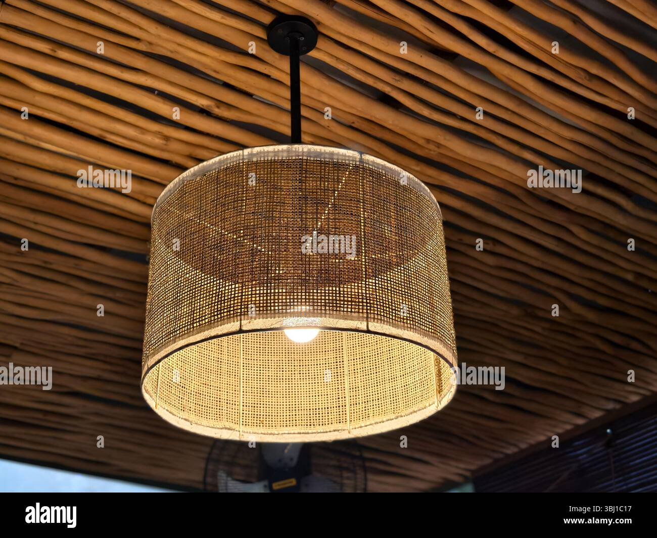 Luce a pendente in rattan calda sotto il soffitto di bambù Foto Stock