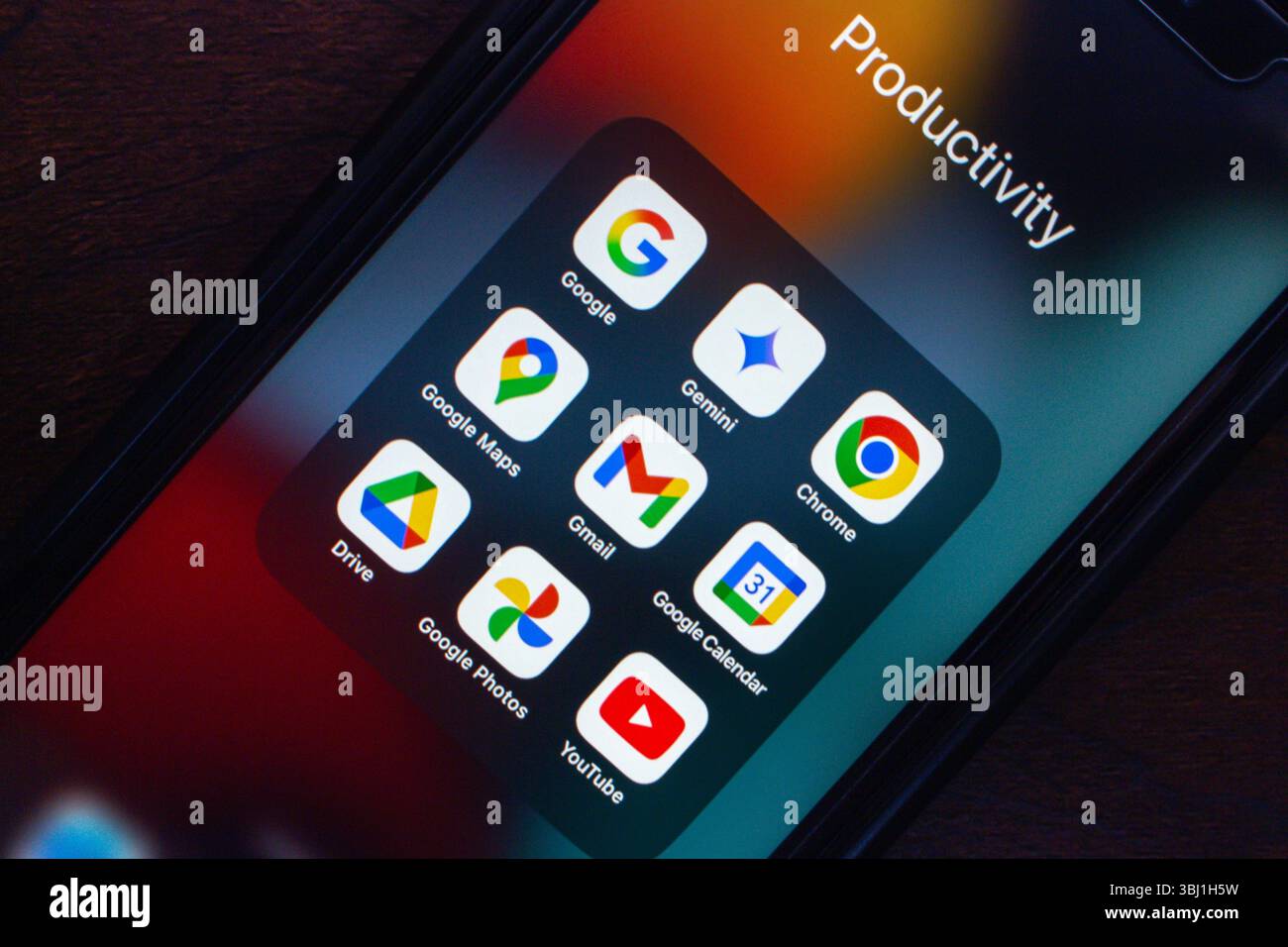 Varie app per la produttività di Google come Gemini, Chrome, Maps, Gmail, Drive, le foto e YouTube vengono visualizzate sullo schermo di uno smartphone. Foto Stock