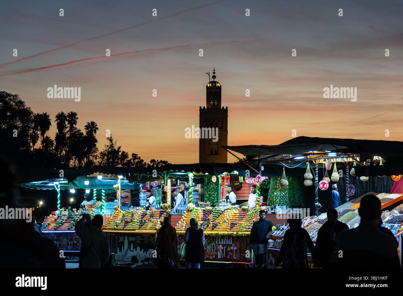 Marrakech, Marocco - 20 febbraio 2025: I turisti passeggiano nella famosa piazza Jemaa el-Fnaa con il minareto Koutoubia a Marrakech Med Foto Stock
