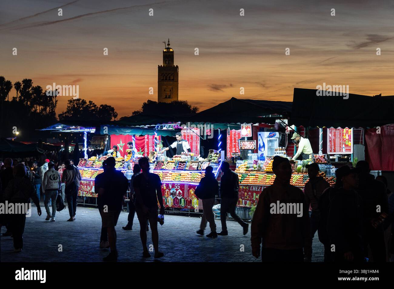 Marrakech, Marocco - 20 febbraio 2025: I turisti passeggiano nella famosa piazza Jemaa el-Fnaa con il minareto Koutoubia a Marrakech Med Foto Stock