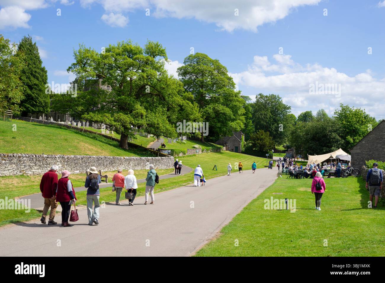 Tissington Well dressings 2025 - persone che cercano le medicazioni del pozzo a Tissington Derbyshire Peak District Derbyshire, Inghilterra Gran Bretagna Europa Foto Stock