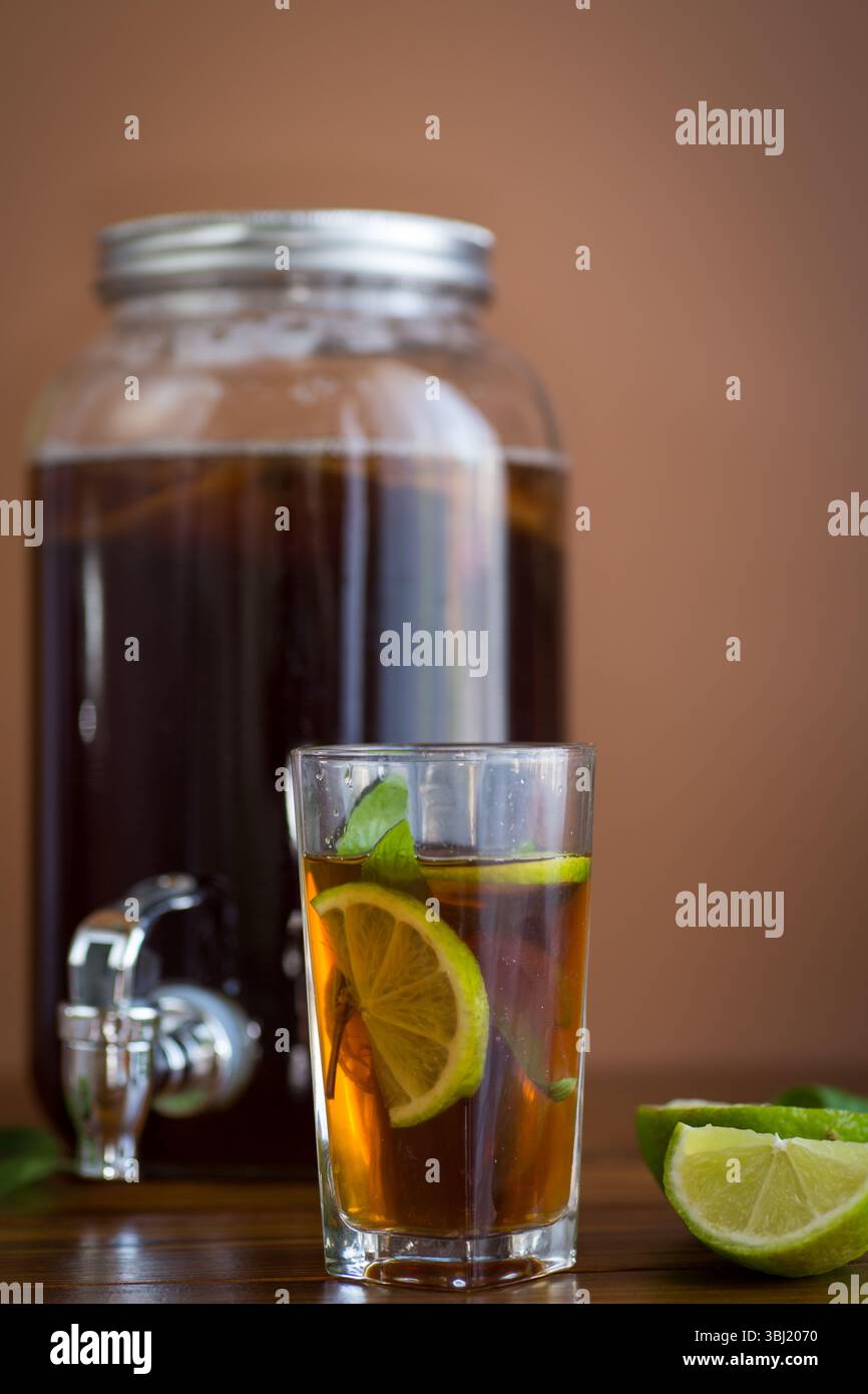 Un kombucha rinfrescante in un vaso di vetro e un bicchiere con lime. Foto Stock Un kombucha rinfrescante in un vaso di vetro e un bicchiere con lime. Foto Stock