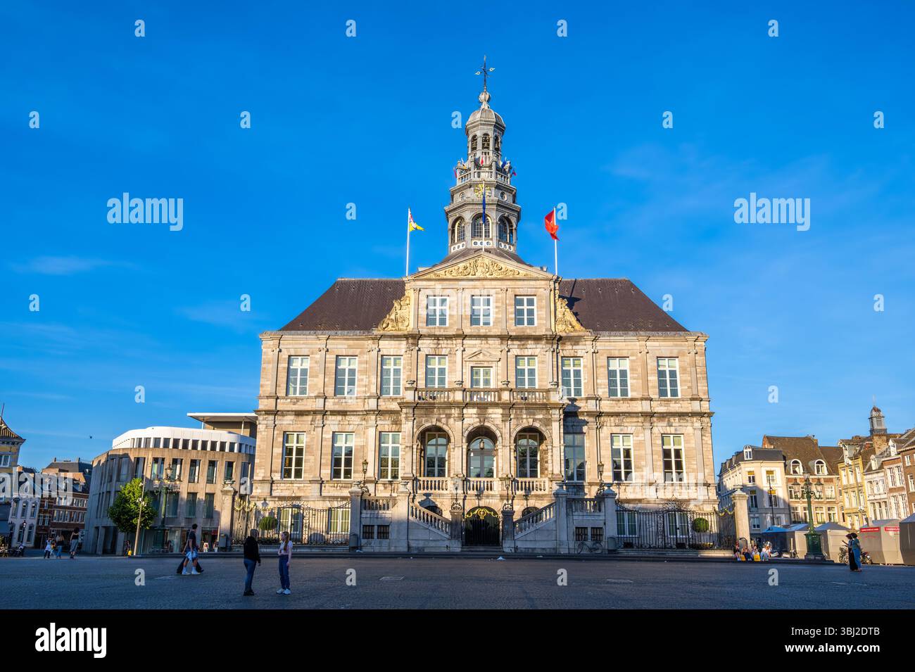Maastricht, Paesi Bassi - 12 maggio 2025: Un municipio storico di Maastricht con un'alta torre dell'orologio, con intricati dettagli architettonici e un Foto Stock