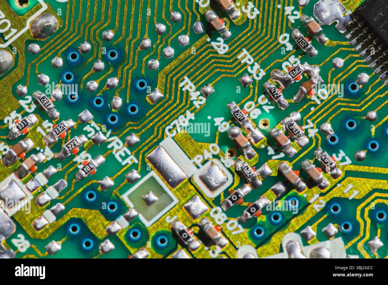 Una vista dettagliata di una scheda a circuito stampato verde che mostra percorsi elettronici, tracce e componenti utilizzati nelle applicazioni tecnologiche e ingegneristiche Foto Stock