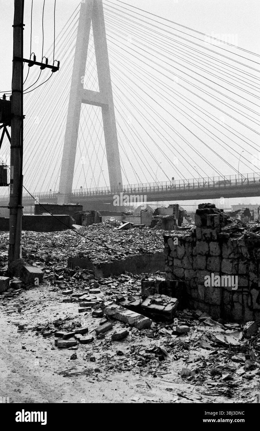 Rovine di demolizione coperte di neve sotto il ponte strallato alla fine degli anni '2000 a Jinan, Shandong, Cina Foto Stock
