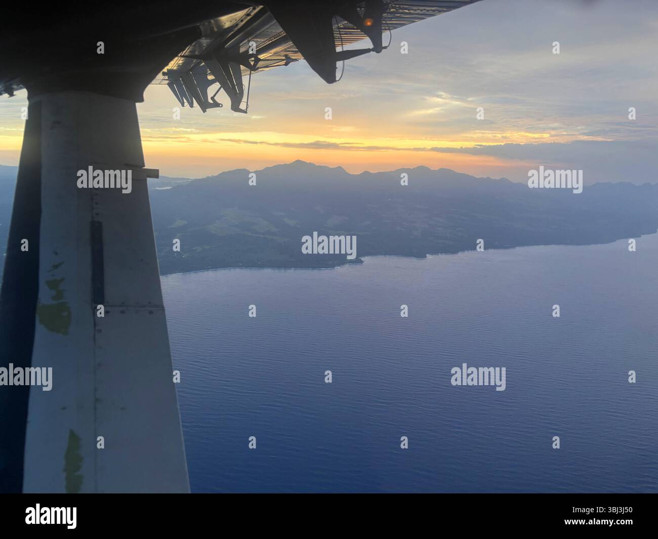 Piccolo aereo che arriva per atterrare sopra Guadalcanal occidentale al crepuscolo, Isole Salomone Foto Stock
