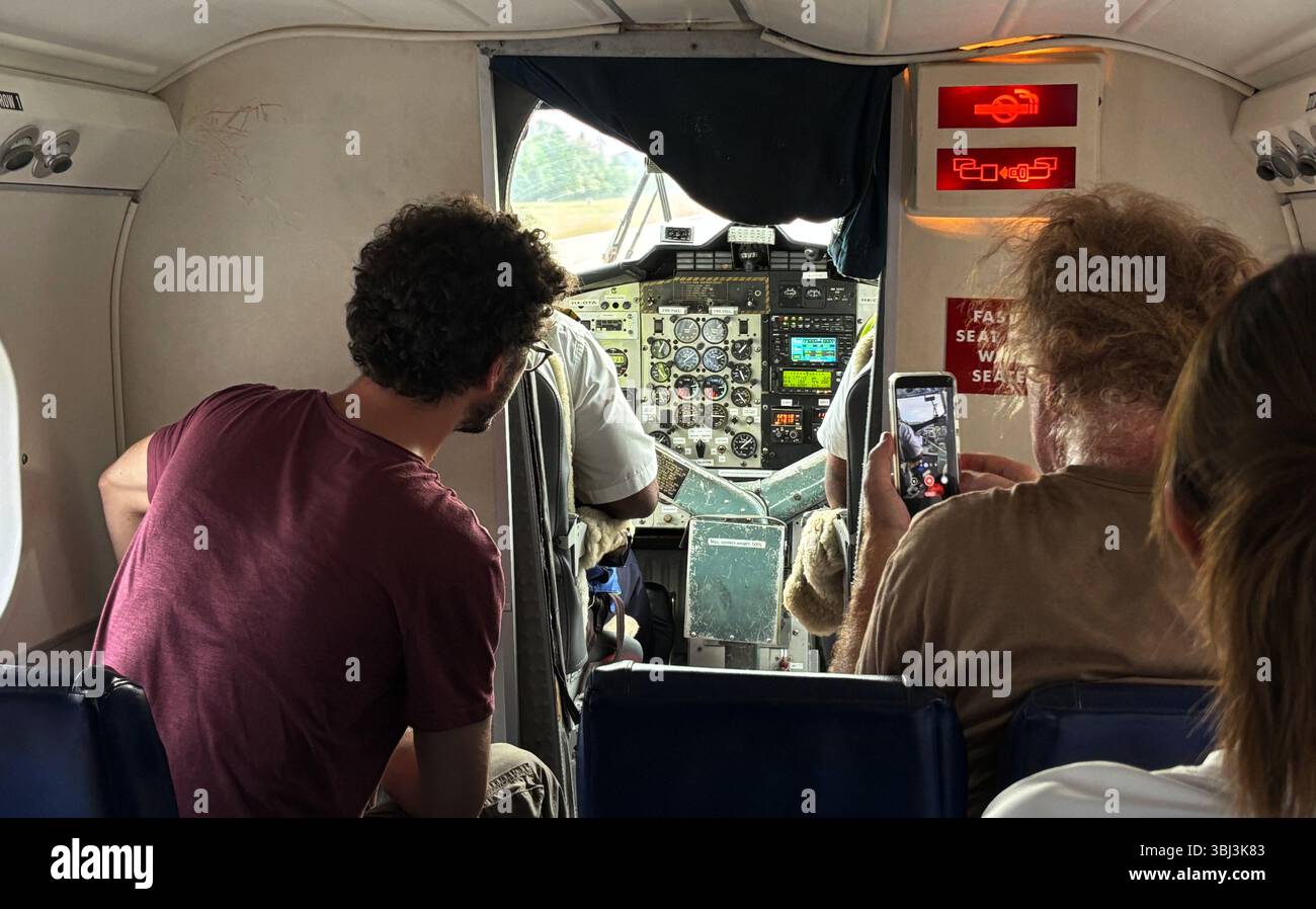 Passeggeri interessati alla cabina di pilotaggio di un piccolo aereo, Solomon Islands Airlines, maggio 2025. No MR o PR - Immagine stock catturata con smartphone