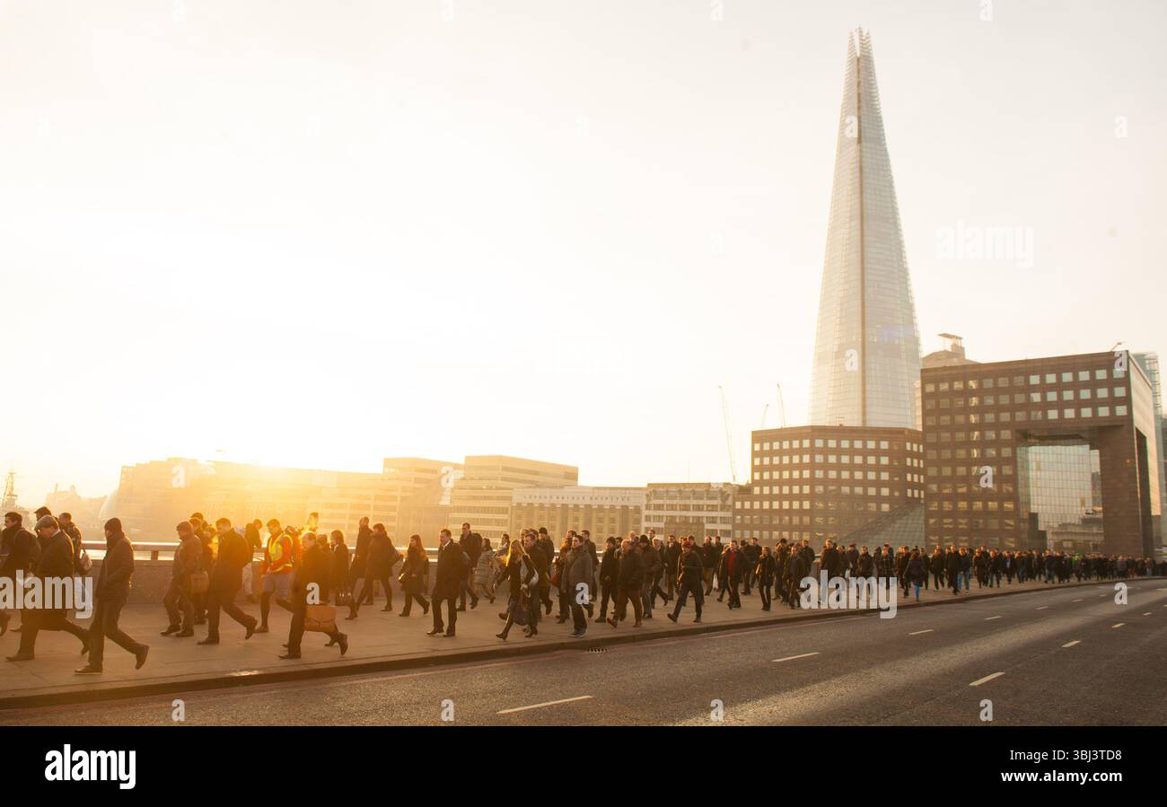 Foto datata 23/01/15 di pendolari visti con l'edificio Shard mentre attraversano il London Bridge, nel centro di Londra, durante l'ora di punta mattutina. Secondo i recruiter, la disponibilità di candidati a posti di lavoro è aumentata al tasso più elevato da oltre quattro anni. Data di pubblicazione: Venerdì 13 giugno 2025. Foto Stock