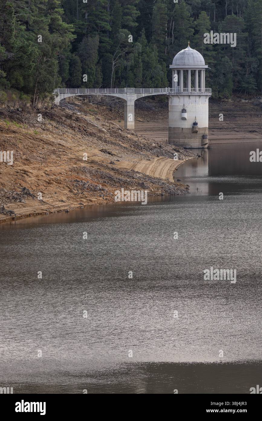 Parete della diga dell'acqua del serbatoio di Maroondah a basso livello che mostra la torre di aspirazione Foto Stock