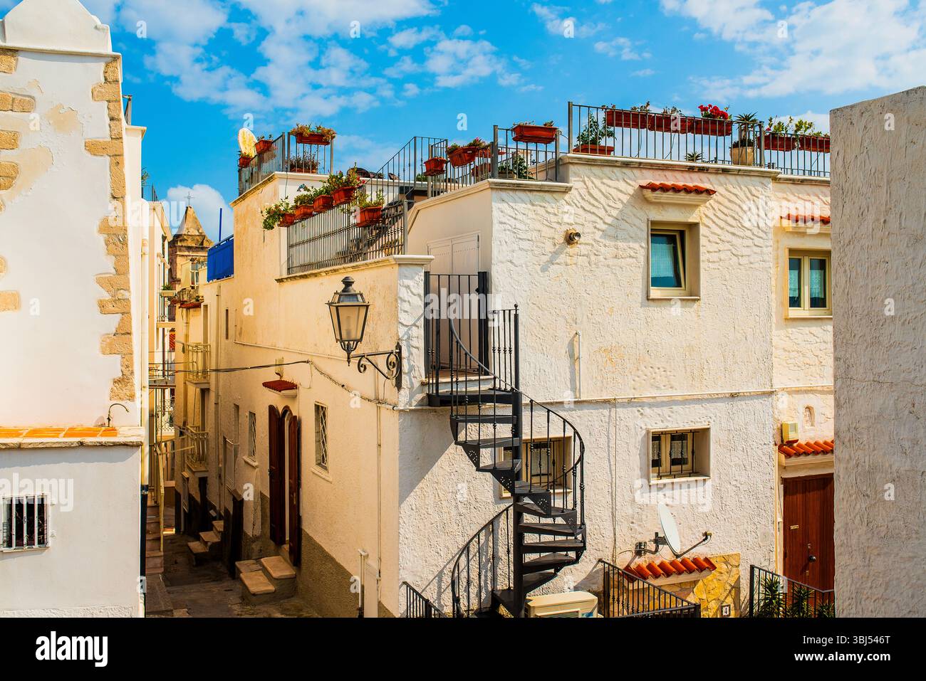 I colorati edifici in stucco fiancheggiano un'affascinante strada italiana del villaggio, piena di consistenza e carattere, popolare tra i turisti per il suo fascino pittoresco. Foto Stock