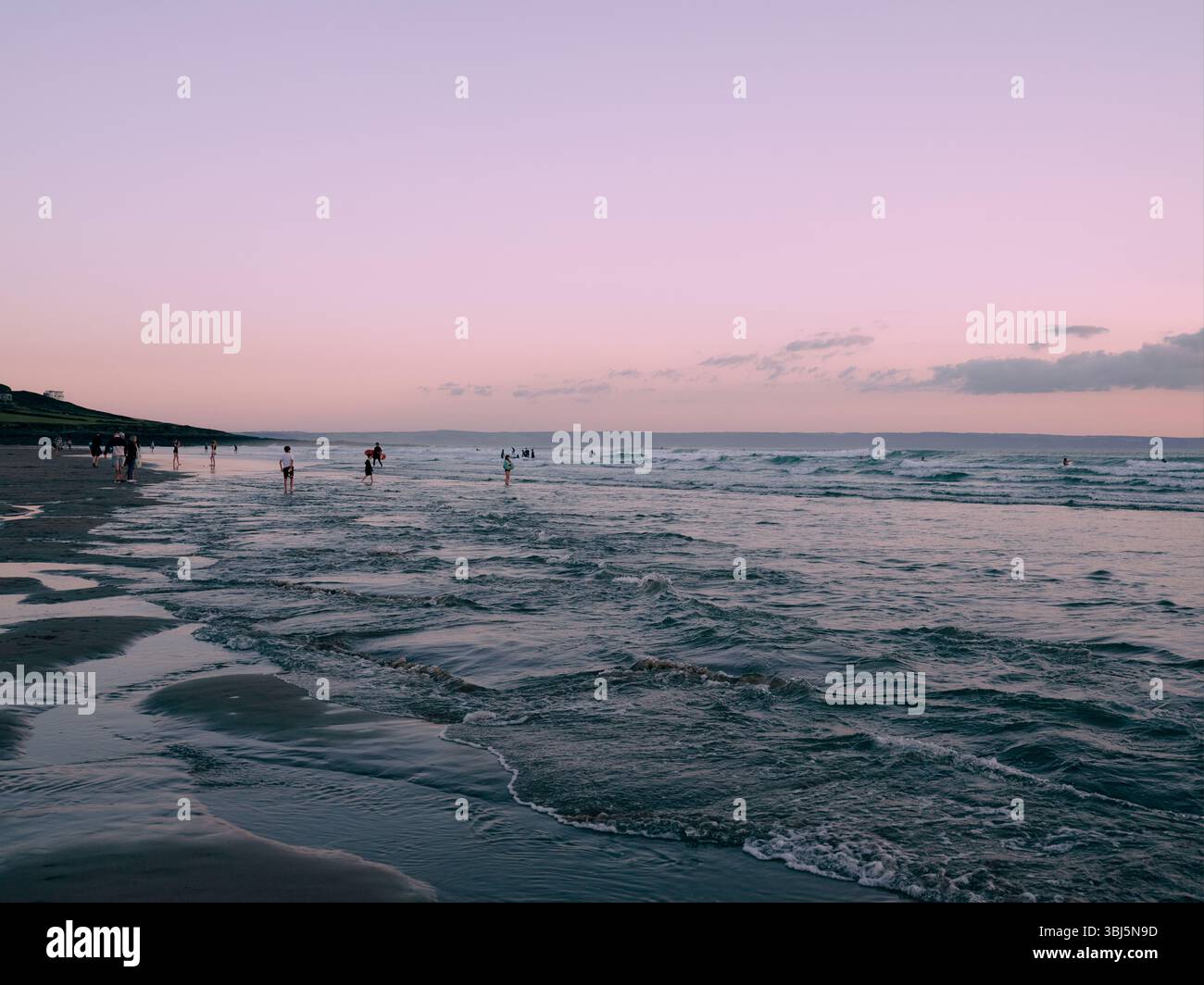 Persone che si godono il mare al crepuscolo Croyde Beach North Devon Inghilterra Regno Unito Foto Stock